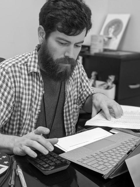 A worker going through harvest paperwork at his desk