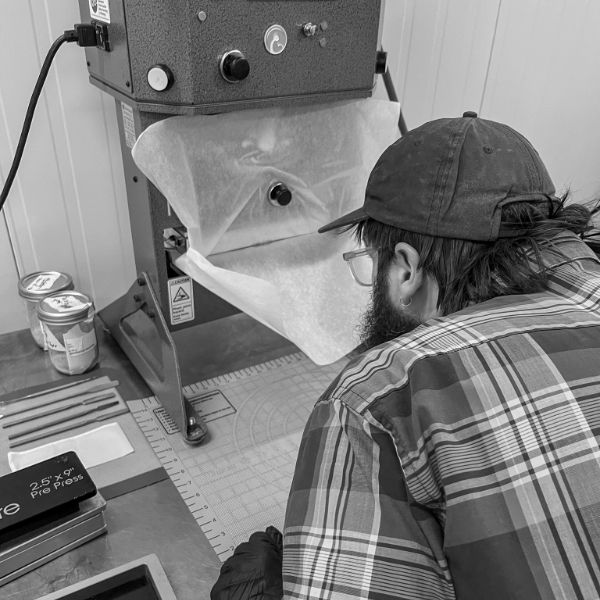 A worker loading the rosin press